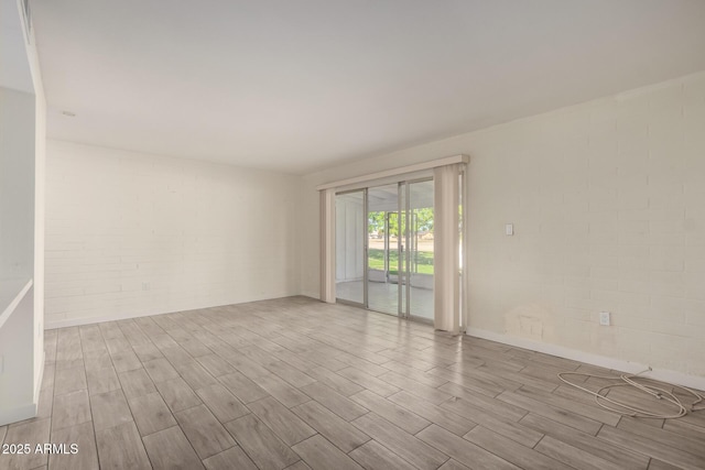 spare room featuring brick wall