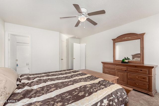 bedroom with ceiling fan, ensuite bath, and light carpet