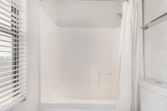 bathroom with shower / bath combination with curtain and toilet