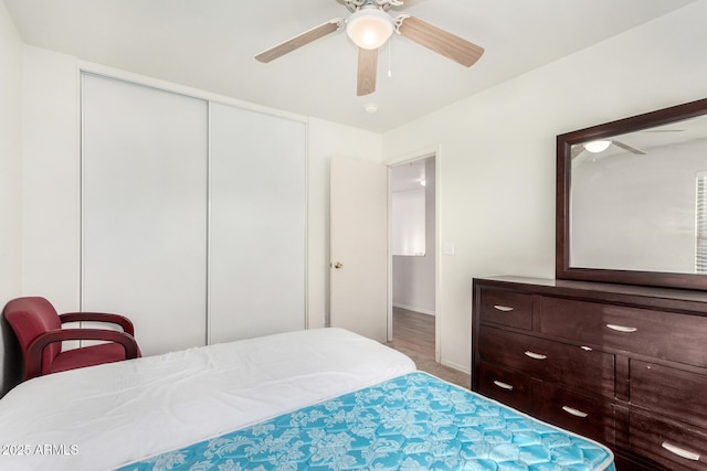 carpeted bedroom featuring ceiling fan and a closet