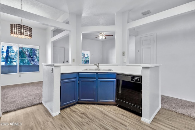 kitchen featuring blue cabinetry, dishwasher, kitchen peninsula, and sink