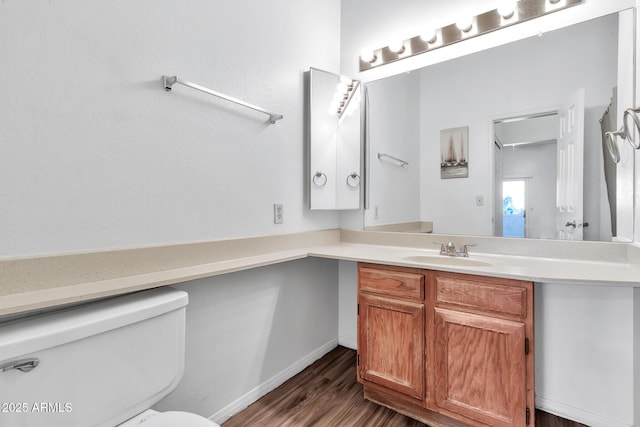 bathroom with hardwood / wood-style flooring, vanity, and toilet