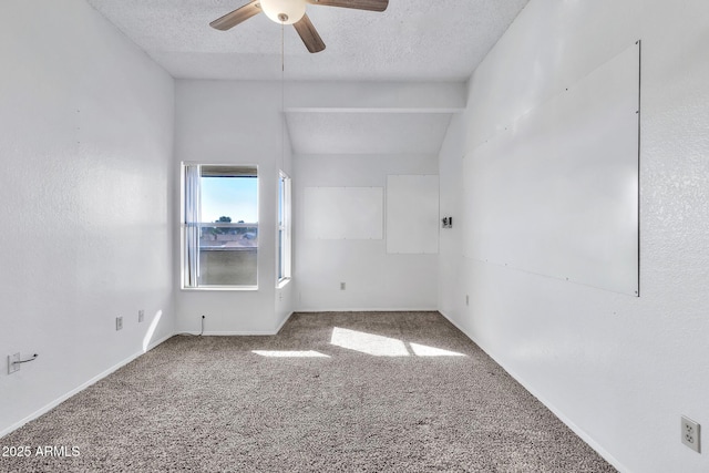 empty room with carpet, ceiling fan, vaulted ceiling with beams, and a textured ceiling