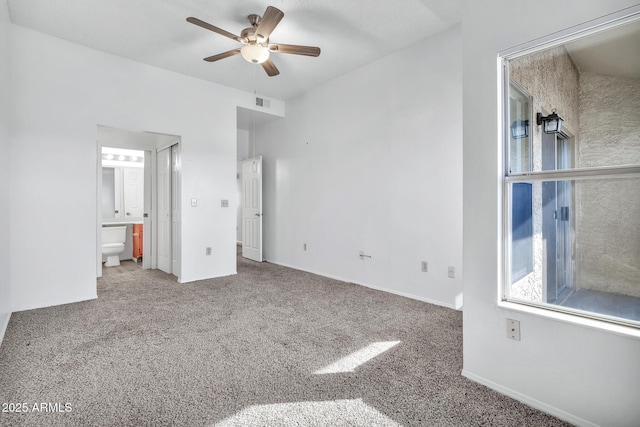 unfurnished bedroom featuring connected bathroom, carpet floors, and ceiling fan