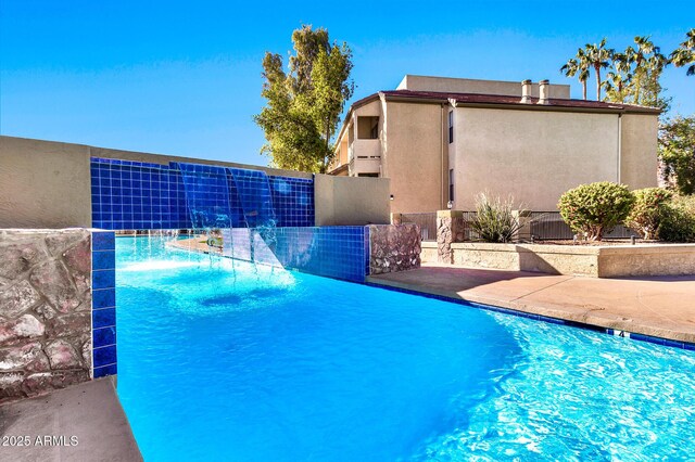 view of swimming pool with pool water feature