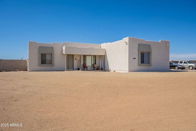 view of front facade featuring fence and stucco siding