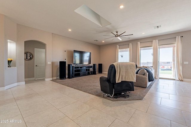 living room with arched walkways, recessed lighting, visible vents, light tile patterned flooring, and baseboards