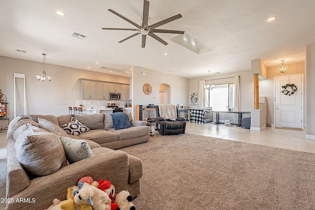 living room with arched walkways, light tile patterned floors, recessed lighting, light carpet, and visible vents