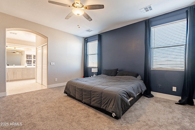 bedroom featuring light carpet, arched walkways, and visible vents