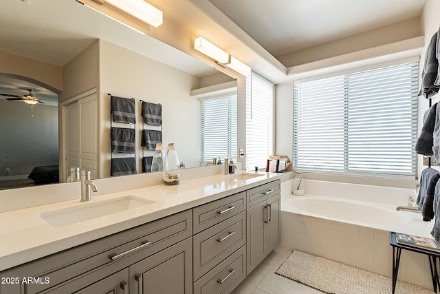 full bathroom featuring double vanity, a ceiling fan, a sink, and tile patterned floors