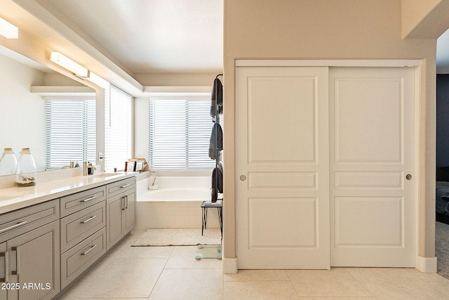 bathroom featuring vanity, a bath, and tile patterned floors