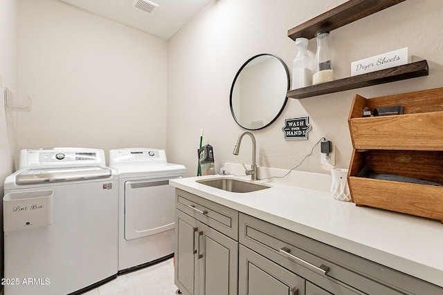 laundry area featuring cabinet space, visible vents, a sink, and washer and dryer