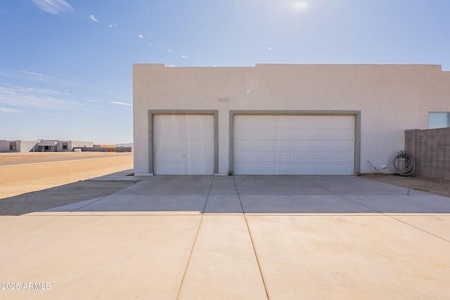 garage featuring concrete driveway