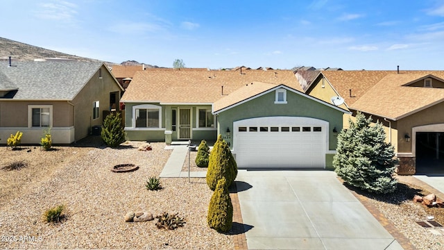 ranch-style house with concrete driveway, roof with shingles, a garage, and stucco siding