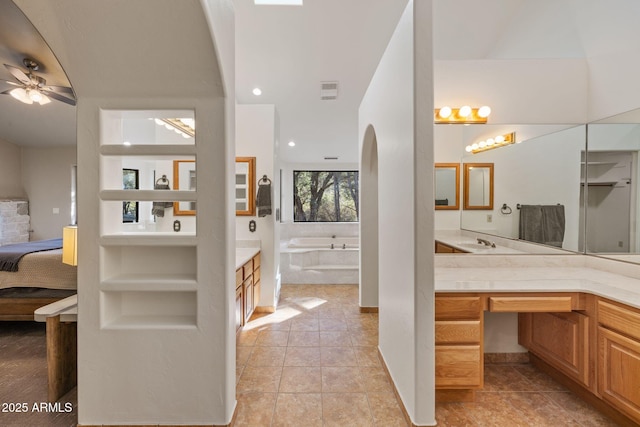 ensuite bathroom with a garden tub, vanity, and ensuite bath