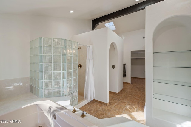 bathroom featuring vaulted ceiling with beams, a walk in closet, a bath, and a shower with shower curtain