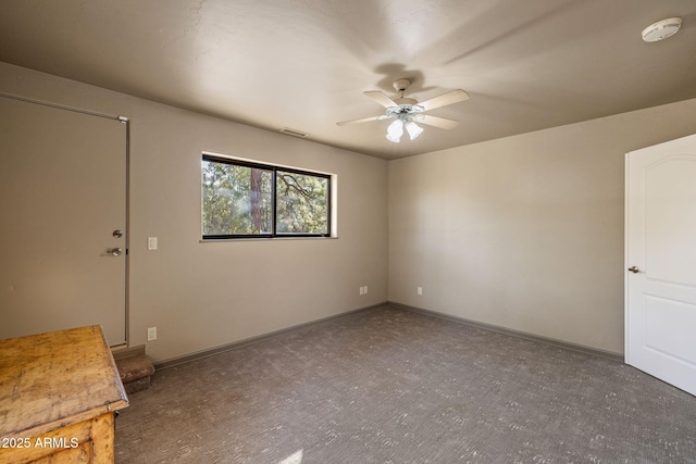 spare room featuring a ceiling fan, visible vents, and baseboards