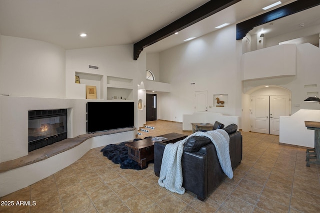 tiled living area with visible vents, a glass covered fireplace, high vaulted ceiling, beam ceiling, and recessed lighting