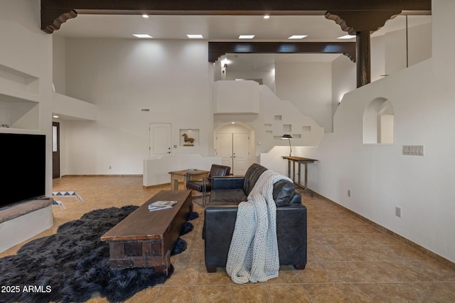 tiled living area with a high ceiling