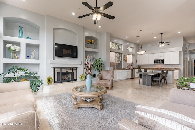 9678 E Voltaire Dr, Scottsdale, AZ 85260 - living room featuring ceiling fan, built in features, a fireplace, and recessed lighting