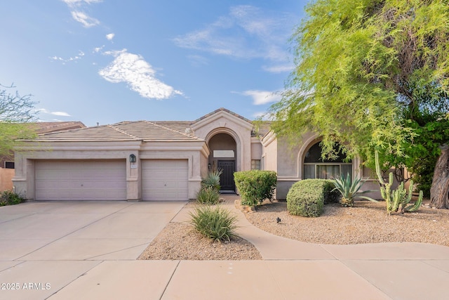 9678 E Voltaire Dr, Scottsdale, AZ 85260 - mediterranean / spanish-style home featuring an attached garage, concrete driveway, stucco siding, and a tile roof