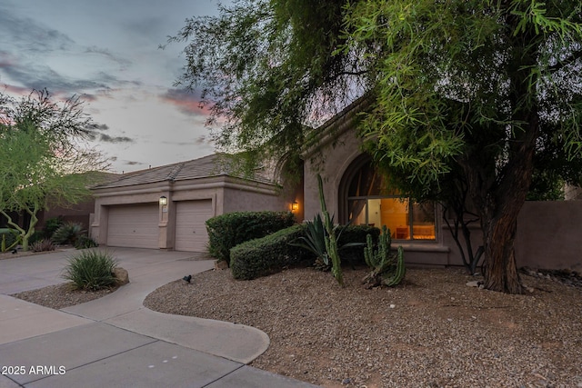 9678 E Voltaire Dr, Scottsdale, AZ 85260 - view of property hidden behind natural elements with driveway, stucco siding, an attached garage, and a tiled roof
