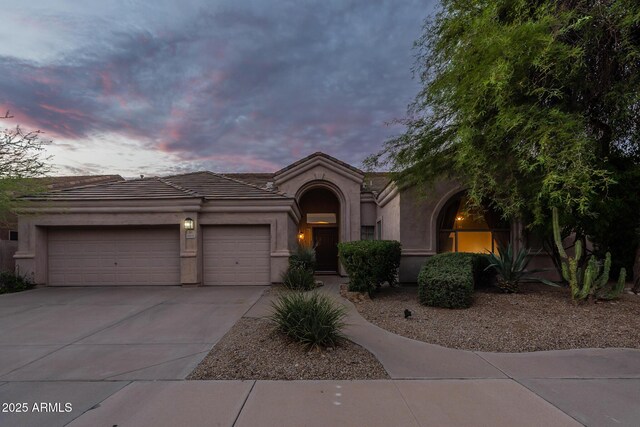 9678 E Voltaire Dr, Scottsdale, AZ 85260 - mediterranean / spanish home with a garage, driveway, stucco siding, and a tiled roof
