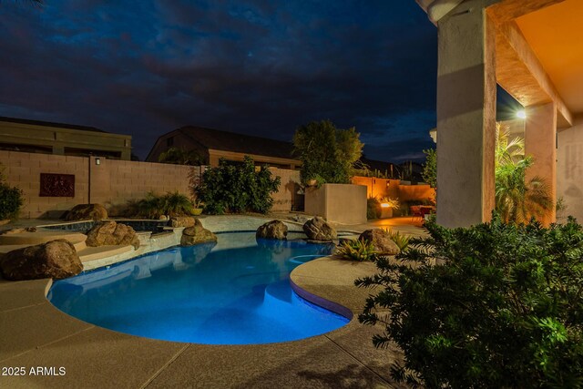 9678 E Voltaire Dr, Scottsdale, AZ 85260 - pool at night featuring a patio area and a fenced backyard