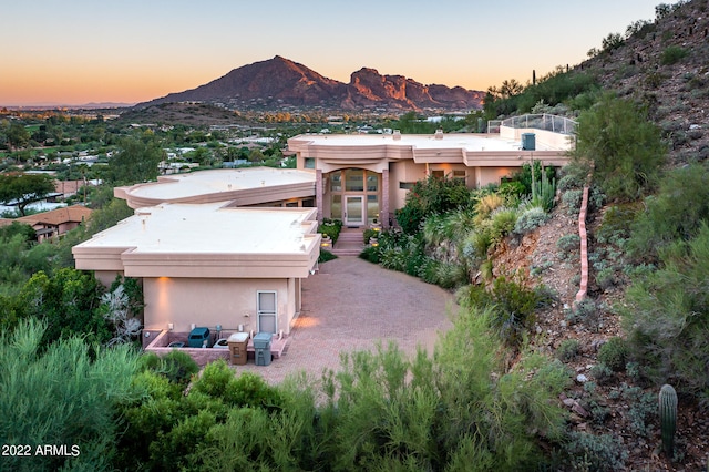 aerial view at dusk featuring a mountain view