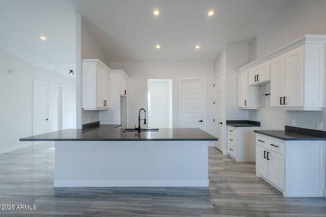 kitchen with sink, a center island with sink, and white cabinets