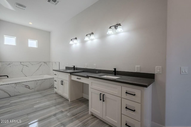 bathroom with vanity, a bathtub, and wood-type flooring