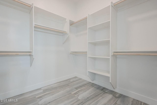 walk in closet with light wood-type flooring