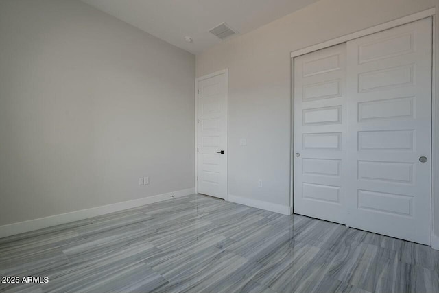 unfurnished bedroom with a closet and light wood-type flooring