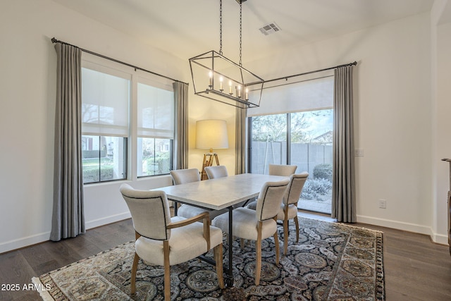 dining room featuring a chandelier, a wealth of natural light, and dark hardwood / wood-style flooring