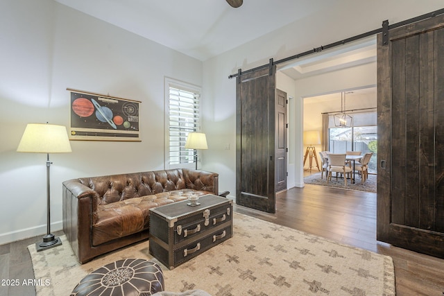 living room with a barn door and light hardwood / wood-style flooring