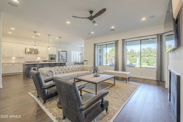 living room featuring hardwood / wood-style floors and ceiling fan