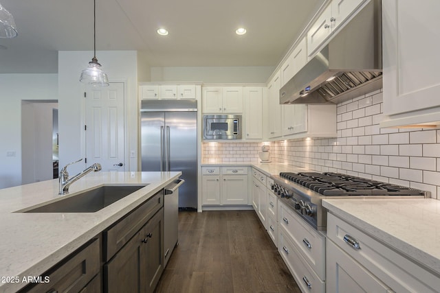 kitchen with ventilation hood, sink, white cabinets, built in appliances, and light stone countertops