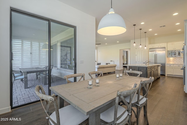 dining space with sink and dark wood-type flooring