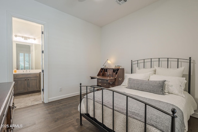 bedroom featuring connected bathroom and dark hardwood / wood-style flooring