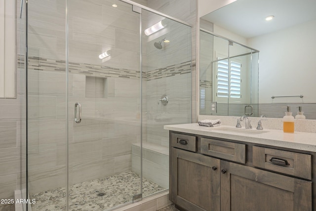 bathroom with a shower with door and vanity