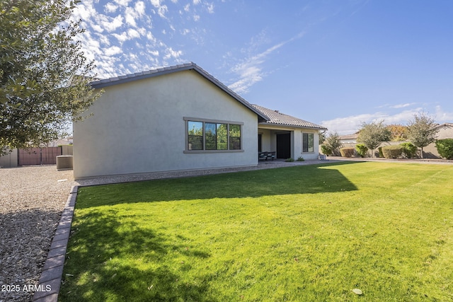 back of house featuring central AC and a lawn