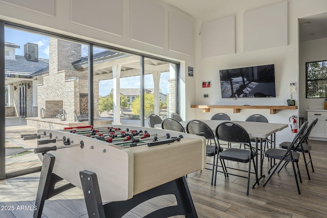 rec room featuring hardwood / wood-style floors and a high ceiling