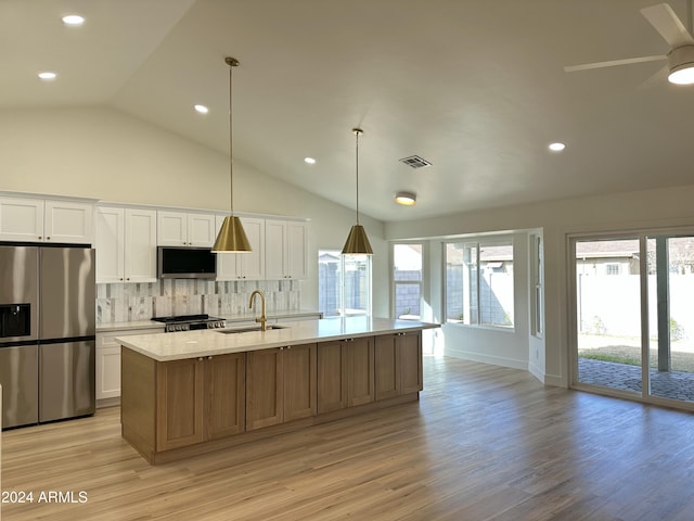 kitchen featuring decorative backsplash, an island with sink, white cabinets, and stainless steel appliances