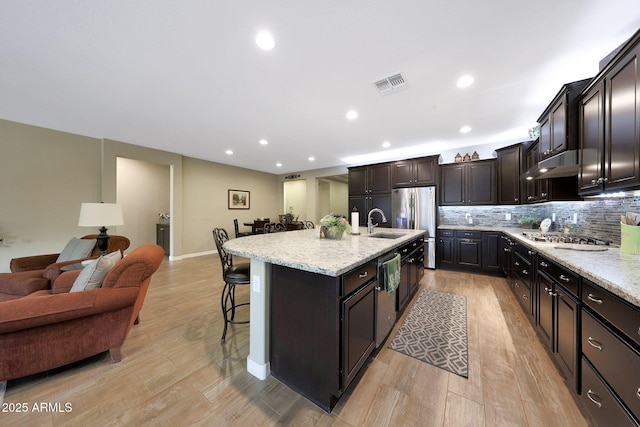 3359 E Penedes Dr, Gilbert, AZ 85298 - kitchen featuring open floor plan, stainless steel appliances, a sink, a kitchen bar, and light wood-style floors