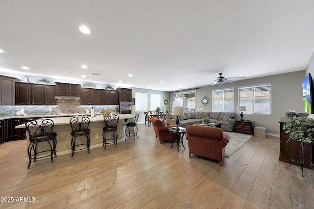 3359 E Penedes Dr, Gilbert, AZ 85298 - living area with a ceiling fan, healthy amount of natural light, light wood-type flooring, recessed lighting, and baseboards