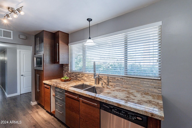 kitchen with visible vents, decorative backsplash, wood finished floors, stainless steel appliances, and a sink