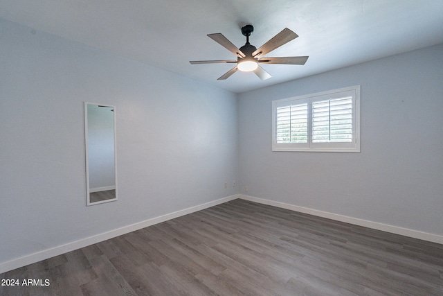 empty room with ceiling fan, dark wood-style flooring, and baseboards