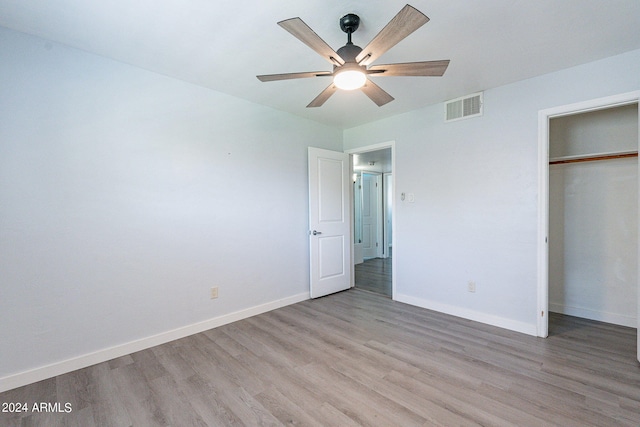 unfurnished bedroom with a closet, visible vents, a ceiling fan, light wood-type flooring, and baseboards