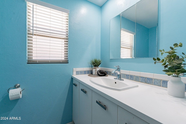 bathroom with a textured wall and vanity