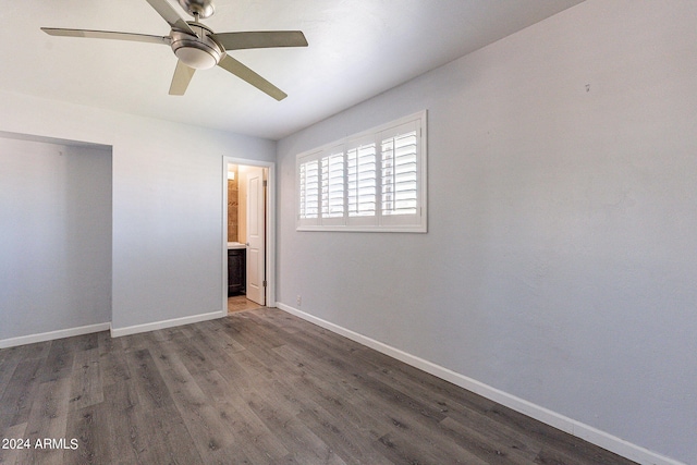 unfurnished bedroom with baseboards, ceiling fan, wood finished floors, ensuite bathroom, and a closet